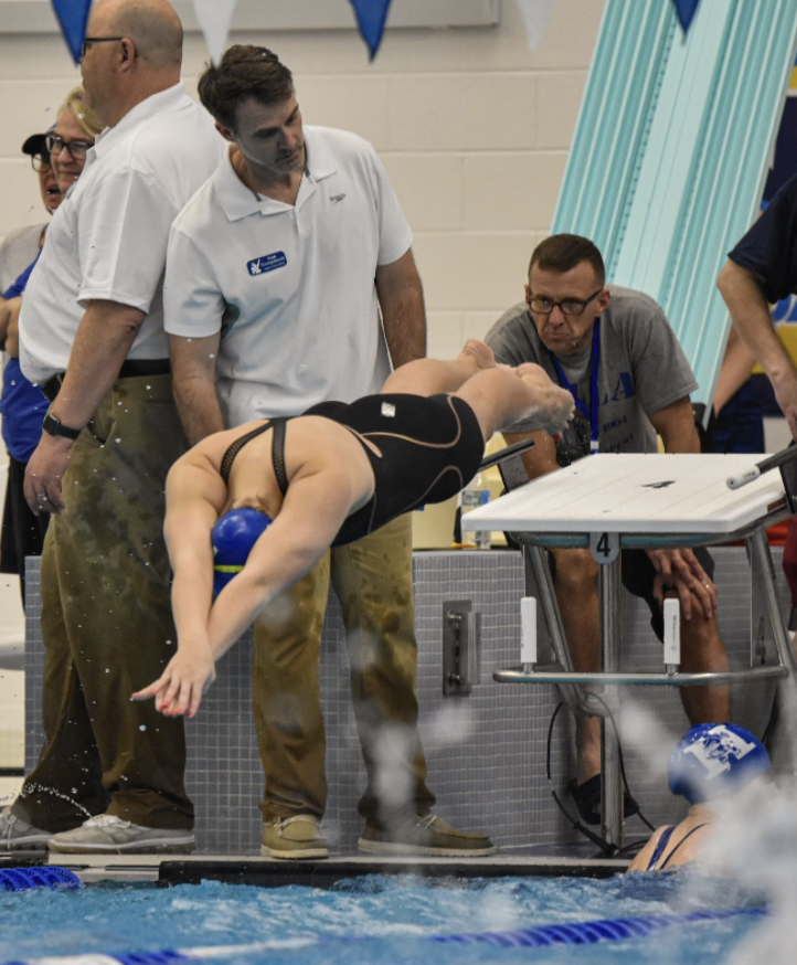 Ragan Moore (11) dives into the pool for the 400-yard freestyle relay.